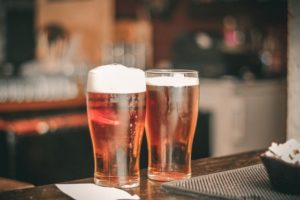 beers in glasses on bar counter.